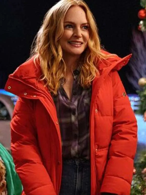 Woman in red puffer jacket smiling at Christmas event with festive decorations