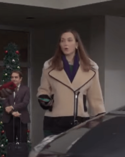 Woman in tan and black winter jacket outside near car, Christmas tree in background