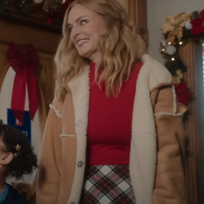 Woman in tan shearling jacket, red top, and plaid skirt at a festive Christmas setting