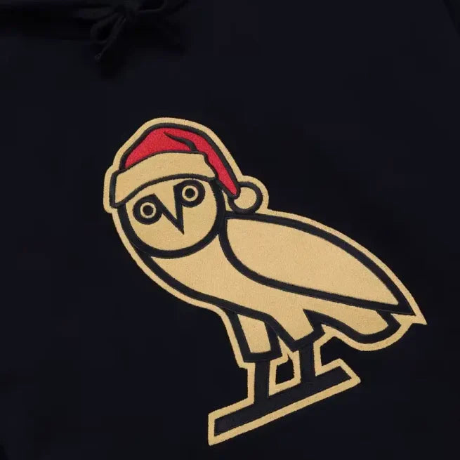 Black hoodie with OVO gold owl logo wearing a red Santa hat, holiday Christmas design