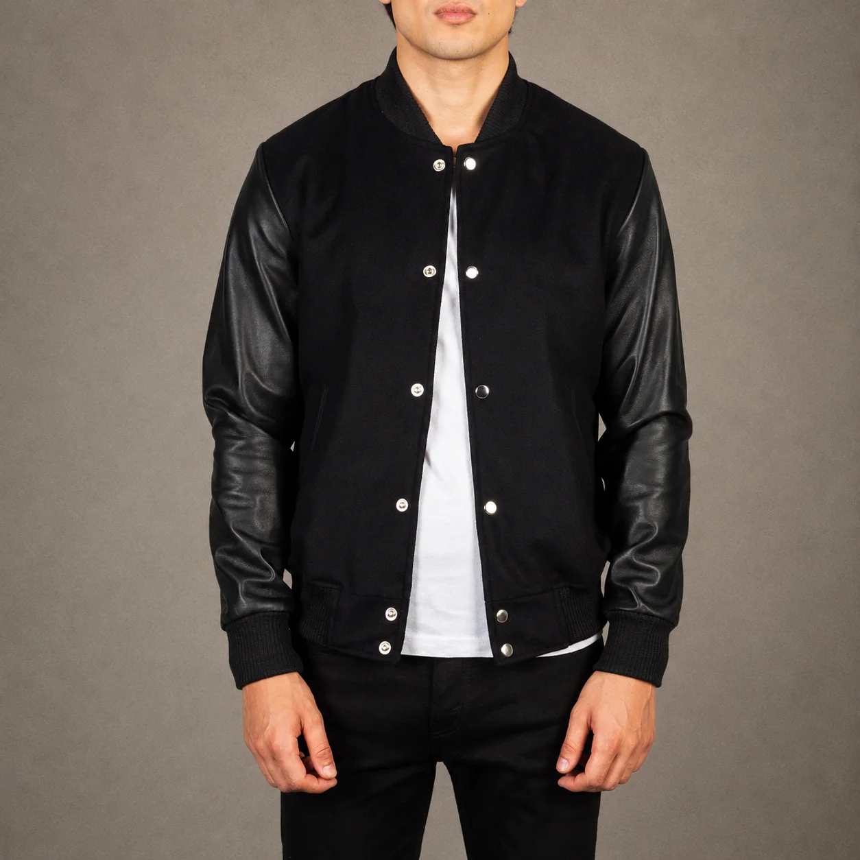 Men's Griffin black hybrid varsity jacket featuring a sleek all-black finish, premium hybrid construction, striped ribbed trims, classic varsity silhouette, durable everyday design, and modern streetwear style by Jonny N Guys